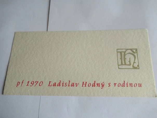 Původní sběratelská novoročenka pf 1970 Ladislav Hodný s rodinou – autor monogramu Oldřich Menhart, slepotisk na ručním papíře (21 × 10 cm)