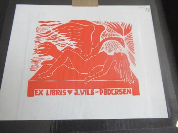Exlibris – J. Vils-Pedersen – Jüri Arrak – motiv: Mytologická a erotická kompozice Leda s labutí v sytě červeném provedení – rozměry 22×15 cm (včetně podkladu), samotný tisk 12,5×10 cm – linoryt / dřevořez (X3 / X1) – 2. polovina 20. století
