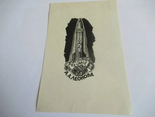 Exlibris – A. A. Leonova – A. Nagowizyn – motiv: Vesmírná raketa Voschod 2 startující z oblaku dýmu nad knihami – rozměry 14×9 cm – dřevoryt (X2) – rok 1965